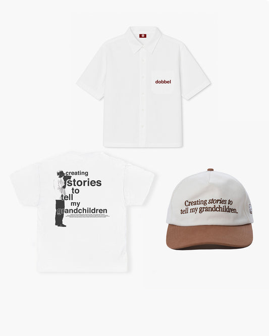 White t-shirt and cap with text 'Creating stories to tell my grandchildren' on a white background